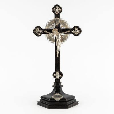 une croix surmontée d'un crâne, posée sur une table