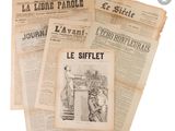 several newspapers are stacked on top of each other on a white surface