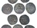 a close up of a bunch of old coins on a white surface