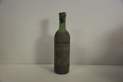 une bouteille posée sur une table blanche