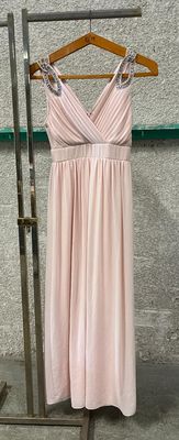 pink dress hanging on a clothes rack in front of a wall