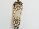 a spoon with a face on it sitting on a table