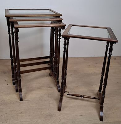 trois tables en bois posées sur un parquet, près d'un mur blanc