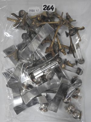 a bag of assorted metal parts on a white surface