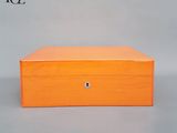 une boîte en bois orange munie d'une serrure sur le dessus