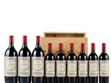 a group of six bottles of red wine in front of a wooden box