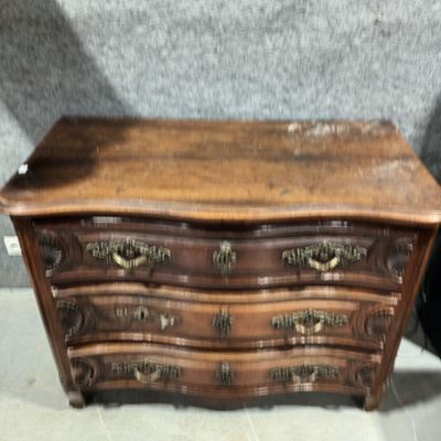 une petite commode en bois exposée dans une pièce
