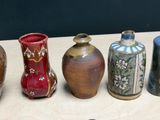 five vases sitting on a table next to each other