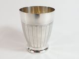 a silver cup that is sitting on a white surface
