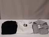 une table blanche sur laquelle sont posées trois paires de chemises noires et blanches