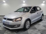 the white volkswagen polo is parked in a room with a checkered floor