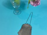 a glass of water and a flower in a vase on a blue table