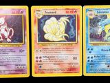 trois cartes Pokémon présentant des motifs différents sur un fond noir