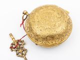 an image of a gold coin purse with a key on a white surface