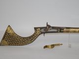an old brass and brass plated pistol with a brass handle