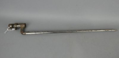 une clé à tube métallique posée sur une surface blanche