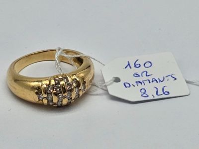 une bague en or sertie de trois diamants, avec une étiquette indiquant son prix