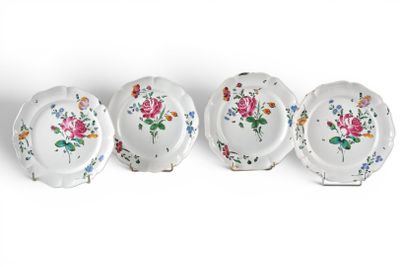 four plates with flowers on them are lined up against a white background
