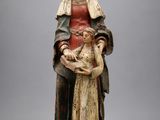 une statue ancienne d'une femme tenant un bébé dans ses bras