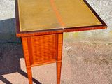 a small wooden table with a glass top on a sidewalk