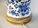 a blue and white vase on a gold stand