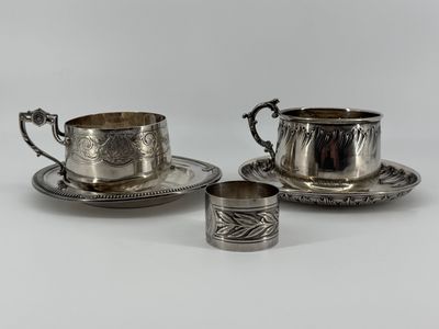 two silverplated cups and saucers