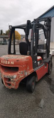 a red forklift truck parked in a parking lot