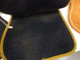 a close up of a black and yellow seat cushion on a chair