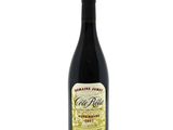 a bottle of red wine sitting on top of a white table