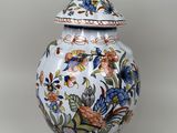 a vase with a lid that has flowers on it