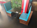a booth with two chairs and a table in the corner