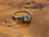 une photo d'une bague en diamant posée sur une table en bois