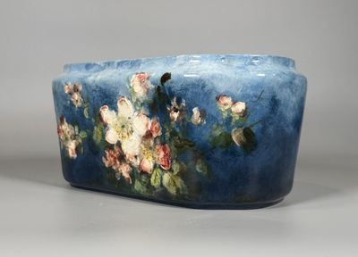 un vase bleu orné de fleurs, posé sur une table