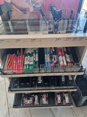 a lot of pens and pencils on the shelf