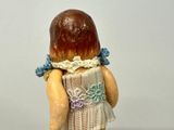 a small figurine of a little girl with a dress on
