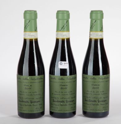 trois bouteilles de vin posées les unes à côté des autres sur une surface blanche