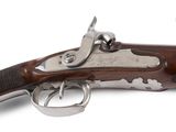 un gros plan d'un pistolet sur une surface blanche avec un fond blanc