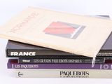 trois livres empilés sur une surface blanche