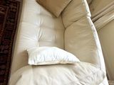 a white couch with pillows on it in a living room