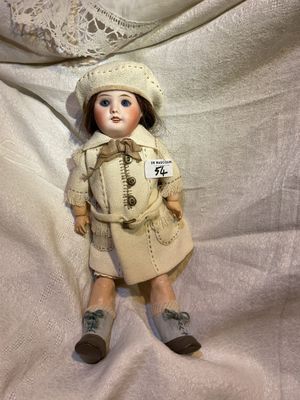 a doll that is laying down on a white sheet