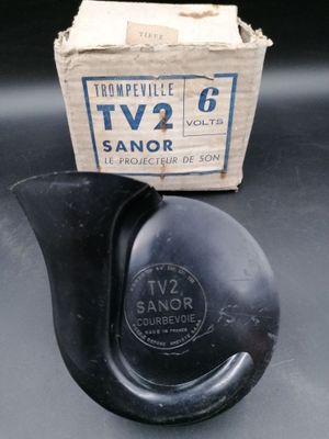 un petit vase noir posé sur une table à côté d'une boîte