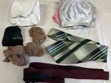 many ties, hats, scarves, and other items laid out on a bed
