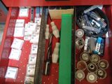 une boîte à outils rouge posée par terre et remplie d'objets divers