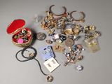 de nombreux bijoux posés sur une table, à côté d'une boîte rouge