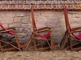a row of chairs that are sitting in front of a building