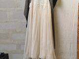 a dress hanging on a clothes rack next to a brick wall