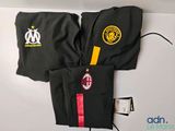 deux pantalons noirs ornés de logos jaunes et rouges