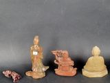 three small figurines of buddhas are sitting on a black surface