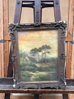 une photo représentant un tableau posé sur un chevalet devant un mur en bois