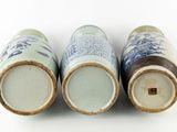 three blue and white vases sitting next to each other on a white surface